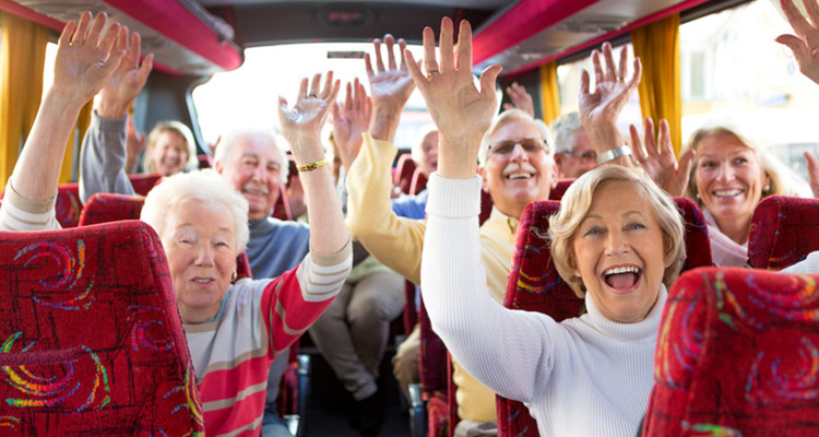 Group of passengers on a bus raising their hands in the air