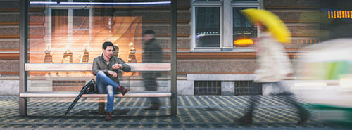 Man at a bus stop on a rainy night